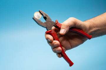 Fototapeta premium a 1 euro coin crushed with pliers. the concept of financial pressure on the currency
