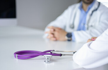 Two doctors discussing and working together in a medical office