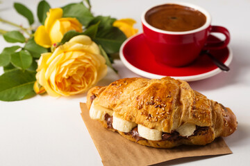 croissant with chocolate, banana and aromatic coffee