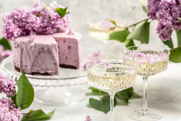 Obraz na płótnie Canvas mousse cake blueberry tart. bouquet of purple blooming lilacs, French cuisine, postcard, background