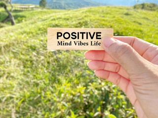 Positive mind vibes life text on wooden block with nature background. Stock photo.