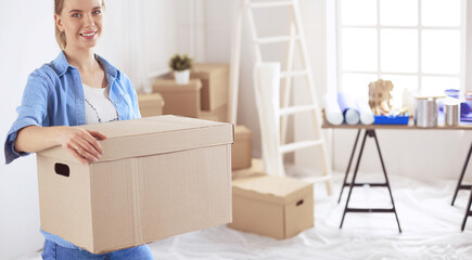 Young woman moving house to new home holding cardboard boxes