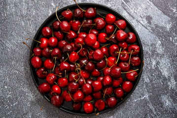 Sweet fresh Cherry on a plate on a stone background