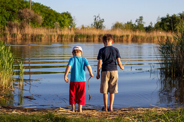 Two boys standing on river. The concept of friendship and brotherhood. Summer vacation