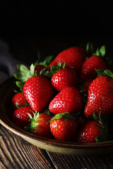 A bowl with ripe bright strawberry in rustic style	