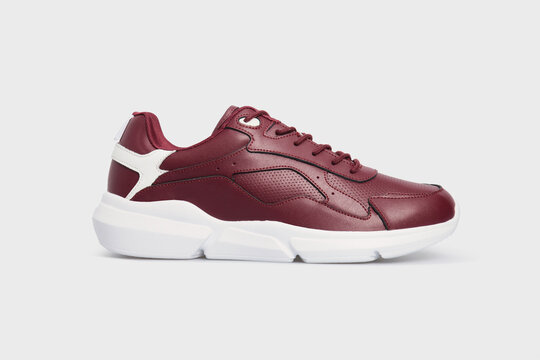 Classic fashion leather women's burgundy pair of sneakers shoes for fitness gym running jogging isolated on white background, placed together