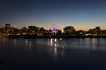 Long exposure of Montreal Downtown skyline during the twilight blue hour with motion blur of Montreal Grand Ferris Wheel