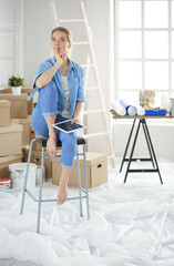 Young woman sitting on a white chair in an empty room, thinking on something