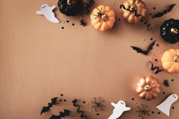 Halloween holiday frame with party decorations of pumpkins, bats, ghosts, spiders on golden...