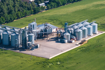 Fototapeta na wymiar aerial view on agro silos granary elevator with seeds cleaning line on agro-processing manufacturing plant for processing drying cleaning and storage of agricultural products in rye or wheat field