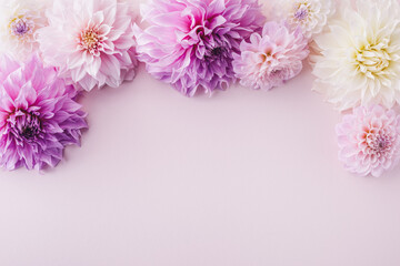 Beautiful pink dahlia flowers on pastel table with copy space for your text top view and flat style. Greeting card for birthday or mother day.