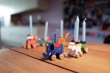 Tischdekoration mit einer Tierparade und Kerzen auf einem Holztisch für einen Kindergeburtstag 