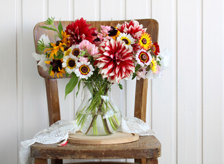 bouquet of garden flowers on a wooden chair.