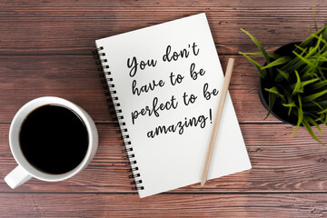 Cup of coffee and note pad with inspirational text - You don't have to be perfect to be awesome