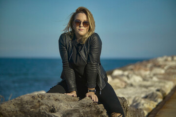 Blonde girl sitting on the rocks