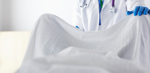 male obstetrician and scrubs nurse are delivered to the pregnant woman in the delivery room of the...