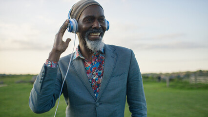 Portrait of happy black male dancing as he listens to music through headphones - Powered by Adobe