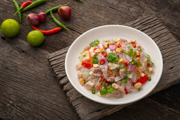 Spicy Glass Noodle Salad with Minced Pork (Yum woon sen) is a type of Thai salad made with clear bean vermicelli and meat in white plate