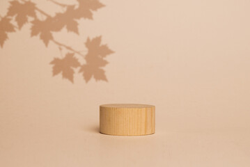 brown box made of precious wood, block, cylindrical podium, branch with maple leaves on a...