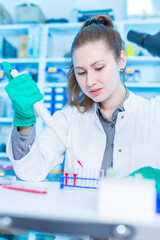 Young female laboratory assistant in laboratory analyzing environmental pollution