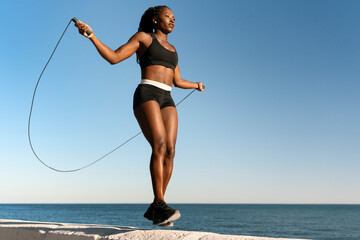 Sporty multiracial woman skipping rope