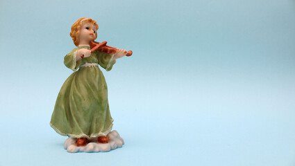 Figura de ceramica de niña tocando un violin. 