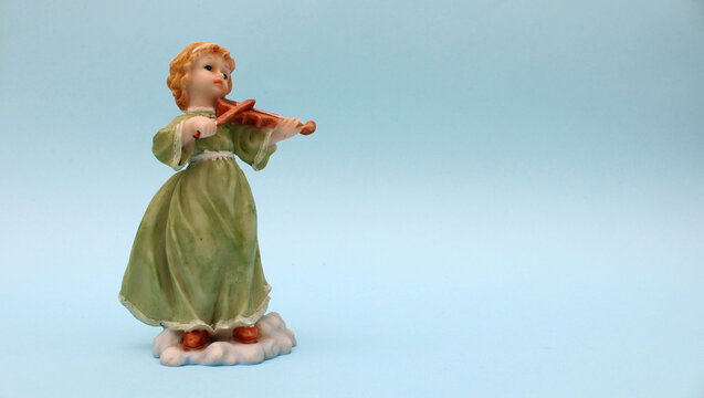 Figura de ceramica de ni&ntilde;a tocando un violin. 