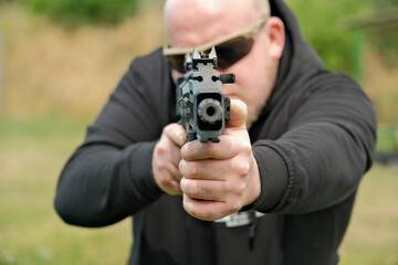 a man threatens with a combat pistol. man holding a gun in his hands
