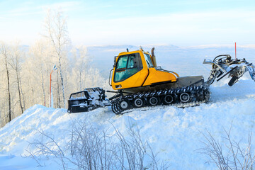 tractor for leveling snow at ski resorts. preparation of a ski track in a forest area