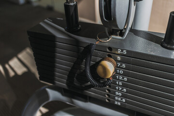 Close up of weight plates machine with yellow pin in the gym.