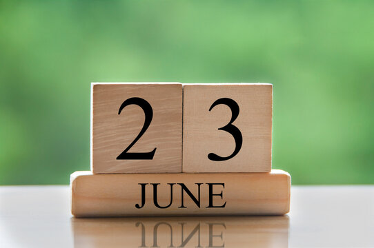 June 23 calendar date text on wooden blocks with blurred nature background. Copy space and calendar concept