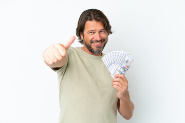 Senior dutch man taking a lot of money isolated on white background giving a thumbs up gesture