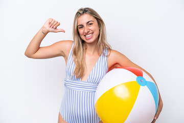 Young caucasian woman holding beach ball isolated on white background proud and self-satisfied