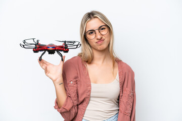 Woman holding a drone over isolated background with sad expression