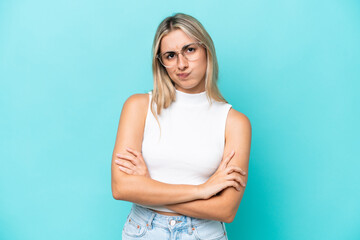 Young caucasian woman isolated on blue background feeling upset