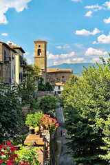 Naklejka premium The hill top town of Poppi, Tuscany, Italy. A steep street climbs past house gardens to the mediaeval Abbey of San Fedele