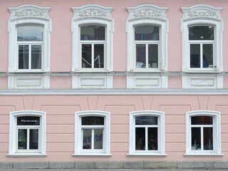 Full-color horizontal photo. Urban landscape. Part of the facade of a historic building. Geometric linear composition with windows.