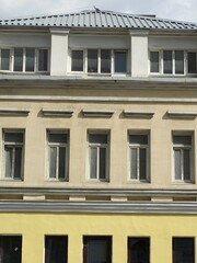 Full-color vertical photo. The geometric composition is made up of sections of the facades of city buildings.