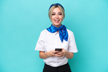 Airplane blonde stewardess woman isolated on blue background surprised and sending a message