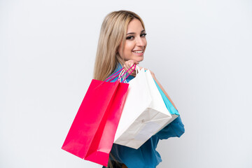 Pretty blonde woman isolated on white background holding shopping bags and smiling