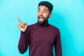 Young Brazilian man isolated on blue background intending to realizes the solution while lifting a finger up