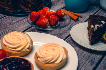 Still life with cream cakes and fresh strawberries.