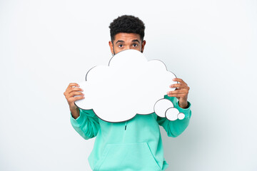 Young Brazilian man isolated on white background holding a thinking speech bubble and hiding behind it