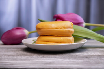 delicious sponge cake in glaze with lilac tulips in the background