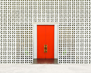 The iconic entrance to the Parker hotel with orangey-red doors and cinder block wall