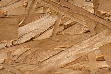 Close up OSB boards are made of brown wood chips sanded into a wooden background. Top view of OSB wood veneer background, tight, seamless surfaces