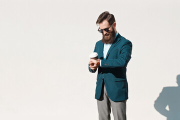 Stylish man with beard wearing a jacket, shirt and bow tie on a sunny day