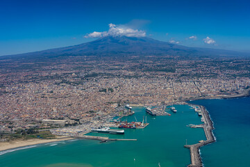 Urlaub und Touristenmagnet auf Sizilien: der Vulkan Ätna von oben aus dem Flugzeug betrachtet mit der Hafenstadt Catania