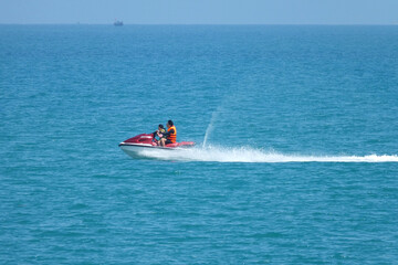  2 persons drive on the jet ski on blue sea water in summer sunny day. Vacation near the sea, travelling concept