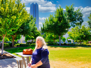 Elderly white woman sitting on park bench admiring the view